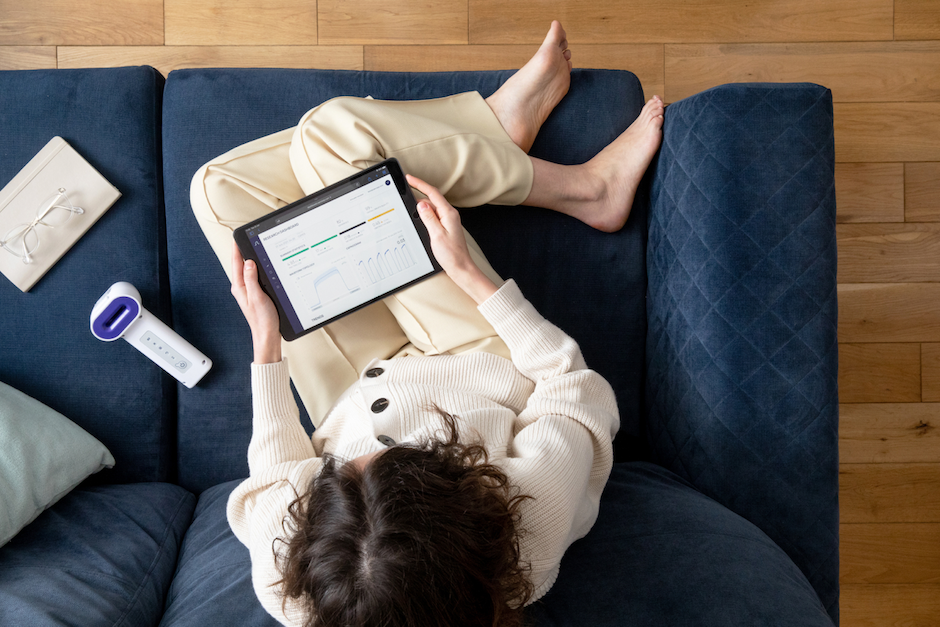 Person sitting and looking at the N-Tidal Diagnose dashboard user interface with an N-Tidal handset next to them